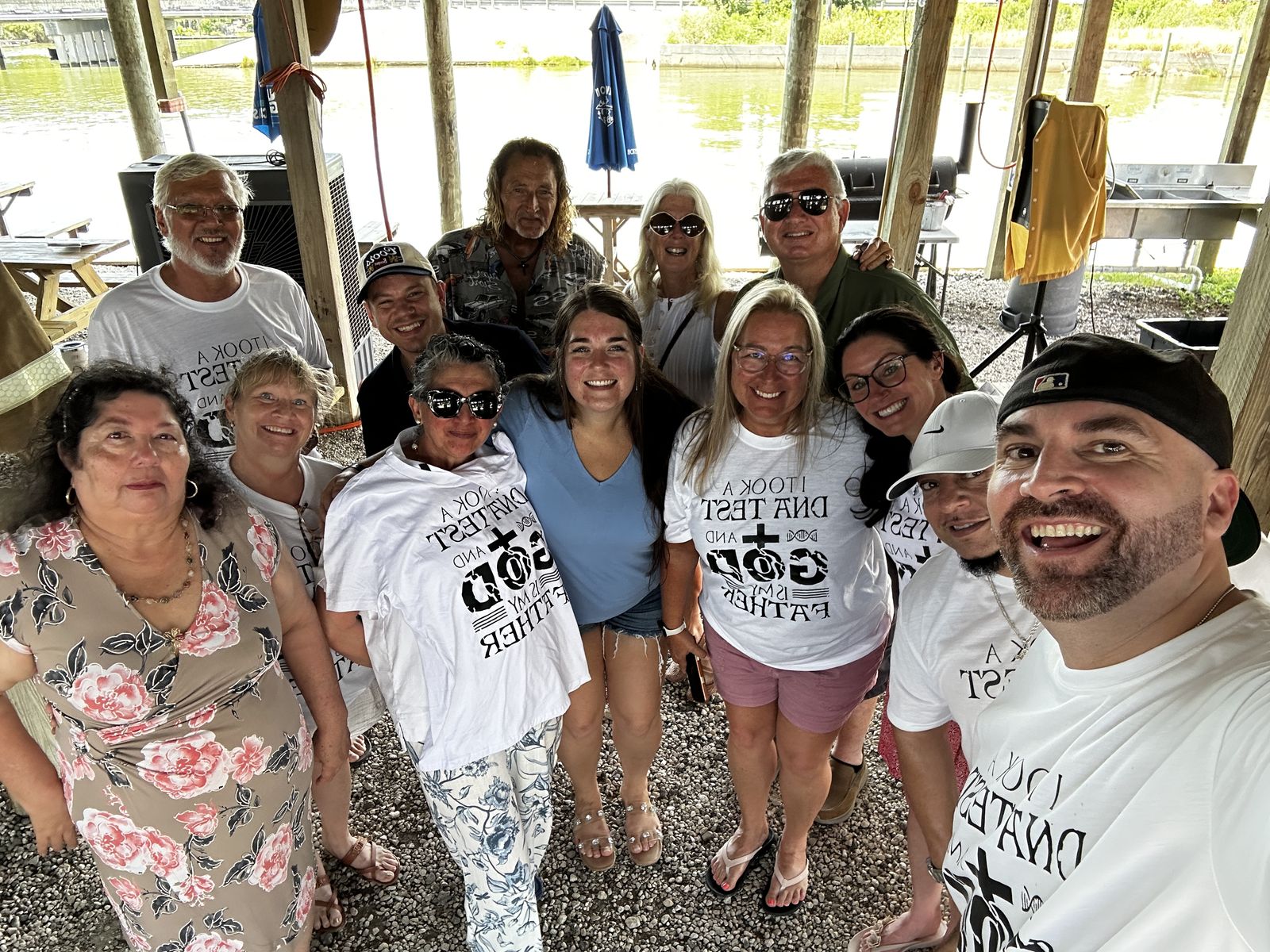 La familia de Lighthouse Community reunida bajo Sammy G&rsquo;s, con el agua detrás